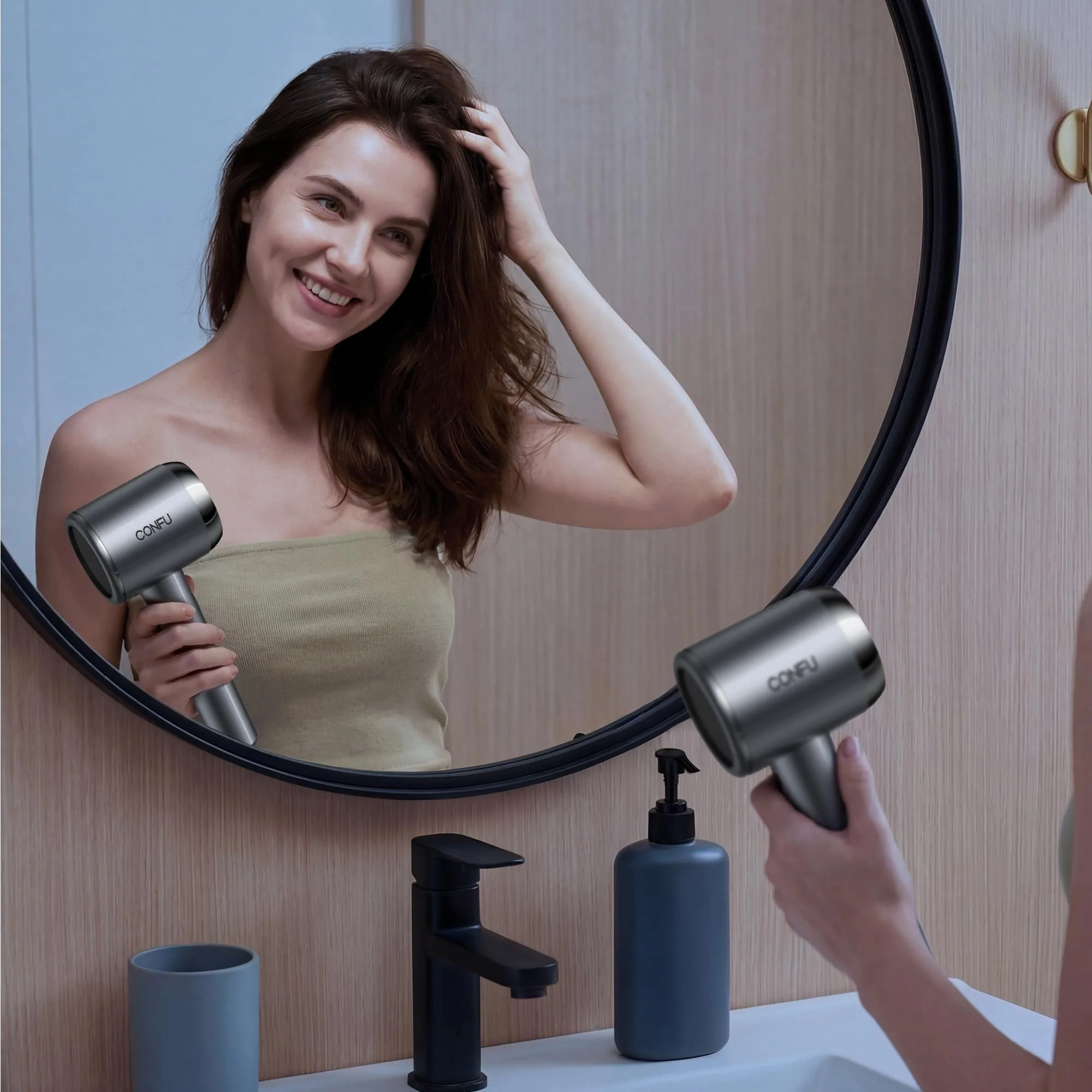A woman drying her hair at a round mirror with the grey CONFU Plasma dryer