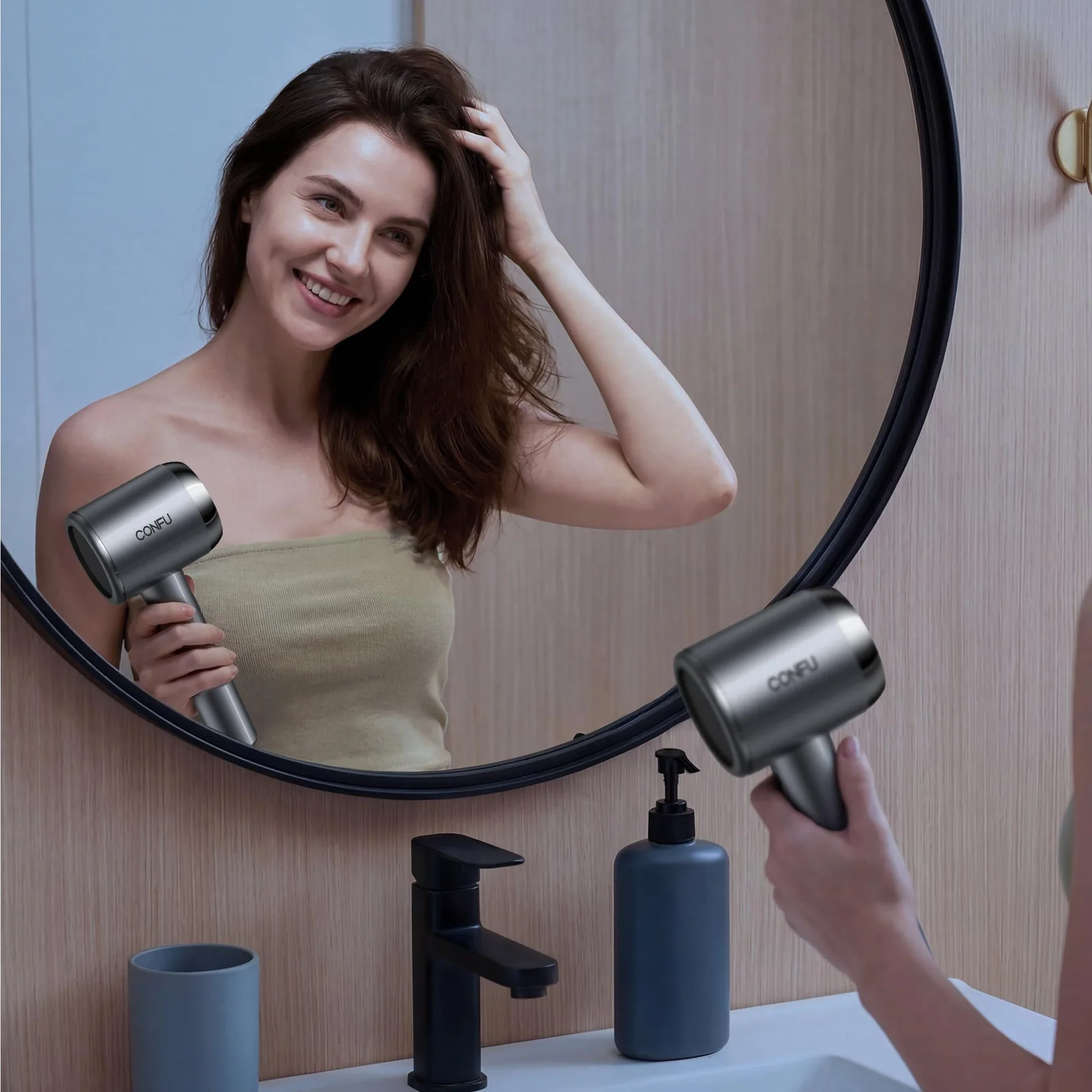 A woman drying her hair at a round mirror with a grey CONFU dryer